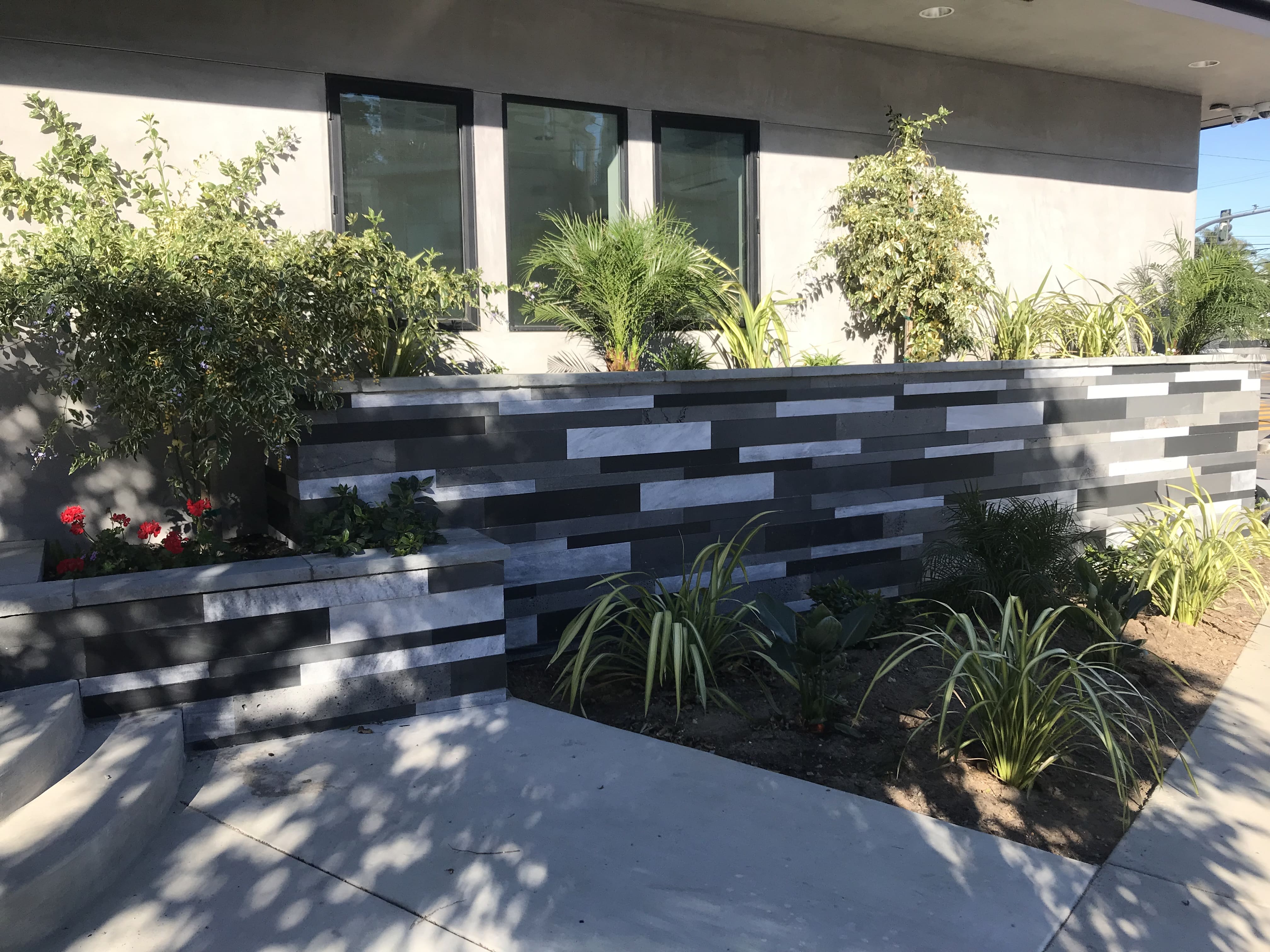 Commercial Exterior Planter and Landscaping wall clad in a mix of four colors of Norstone's Planc Large Format Tile